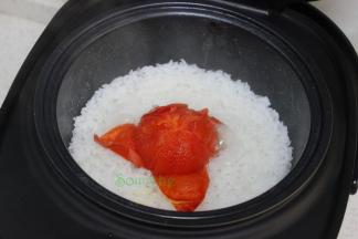 饭煮熟之后，自动跳到保温状态，这个时候开盖，把西红柿的外皮去掉，用筷子把西红柿拌均。