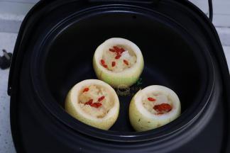 电饭锅倒入适量的水，把准备好的秋梨盅放入巧釜电饭锅里的甑子里，一个电饭锅刚刚好放三个秋梨。