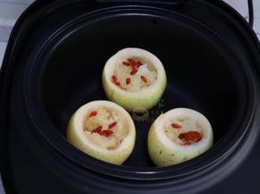 电饭锅倒入适量的水，把准备好的秋梨盅放入巧釜电饭锅里的甑子里，一个电饭锅刚刚好放三个秋梨。