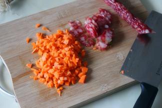 胡萝卜去皮洗净，切粒，腊肠切切片。腊肠的挑选：广东的腊肠是有淡淡甜味，老少都喜欢吃，烟熏味的腊肠，不适合蒸饭，可以炒饭。