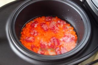 接着放胡萝卜、腊肠均匀放入在大米上，合上电饭锅盖子。能看见大米上面有水，但是菜上面就没有水，这是刚刚好的水量。