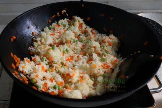 从冰箱取出米饭，放入锅里，旺火爆炒米饭至粒粒分明，能听见吧啦吧啦的响。