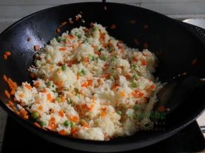 从冰箱取出米饭，放入锅里，旺火爆炒米饭至粒粒分明，能听见吧啦吧啦的响。