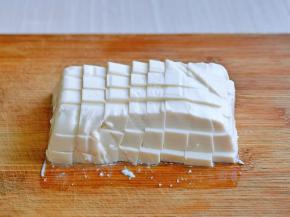 首先将内酯豆腐倒扣再砧板上，再切方块。