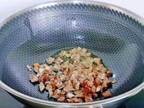 起油锅，加入切好的蒜炒香，再加入牛肉丁煸炒。