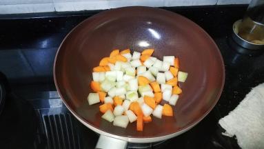 锅里热油放入冬瓜、红萝卜粒炒均匀