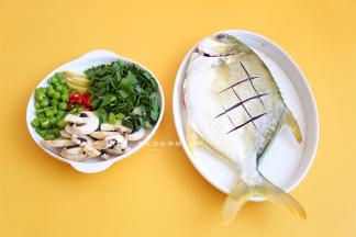 先将鱼开肚取出内脏，清洗干净鱼肚，用刀在鱼身上切出花刀，这会让鱼肉更容易入味，尤其是大个头的鱼，生蒜切碎，蘑菇切厚片，番茄切片，美人椒切小段。