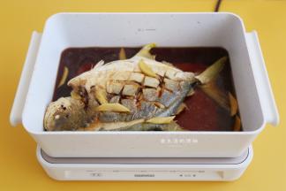 把酱料的食材混合成酱汁，均匀地淋在鱼的身上，放入姜片，轻轻动一下鱼，让酱汁铺到鱼身下，转中火开始焖3分钟。