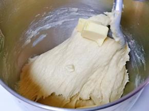 10分钟后面团处于扩展阶段，这时加入室温软化的黄油，启动厨师机3档揉面，揉出不容易破的手套膜即可。