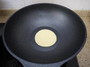 把平底锅烧热，然后转小火，倒入一勺面糊。