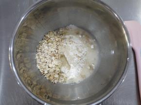 制作包子皮。把燕麦片、中筋面粉、水和酵母放在一个容器中，混合成团之后揉成光滑的面团。