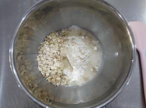 制作包子皮。把燕麦片、中筋面粉、水和酵母放在一个容器中，混合成团之后揉成光滑的面团。