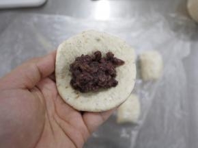 面团松弛好之后，擀扁，然后包入红豆馅。