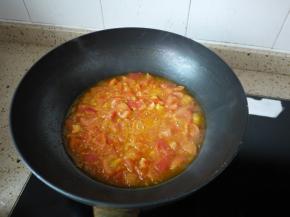 锅里倒少许的油，把大蒜放进去煸炒出香味。然后加入番茄继续用中小火翻炒一会，加入少量的水，煮开后转小火把番茄煮到软。