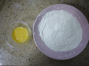 准备一个大碗，把中筋面粉、玉米淀粉、小苏打倒在一起混合均匀。鸡蛋打散备用。