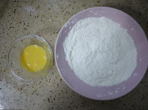 准备一个大碗，把中筋面粉、玉米淀粉、小苏打倒在一起混合均匀。鸡蛋打散备用。