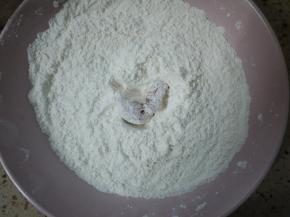 把腌制好的鸡肉先夹出一小块，沾上面粉。
