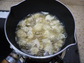锅里倒入适量的花生油，烧到八成热的时候把鸡米花一个一个地放进锅里，炸到定型，用筷子夹一下，鸡米花外壳有点硬，颜色有点金黄色，这时候把鸡米花捞出来。