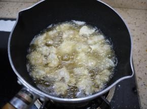 锅里倒入适量的花生油，烧到八成热的时候把鸡米花一个一个地放进锅里，炸到定型，用筷子夹一下，鸡米花外壳有点硬，颜色有点金黄色，这时候把鸡米花捞出来。