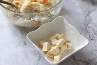 拌好之后的土豆泥，就可以吃了，味道很好吃，不过我们今天要做土豆泥卷，把三角奶酪，切成小块。