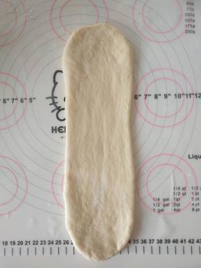 8、取一个面团擀开，翻面，压薄底边、