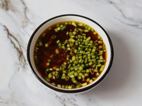 蒸螃蟹的时候来准备蘸料。生姜切末、小葱切成葱花，放入味碟里面，加入1勺生抽、2勺香醋，少许白砂糖和芝麻油，再加入适量清水，搅拌均匀就可以了。