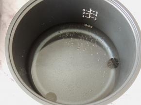 电饭煲的三角釜内放入适量清水，水量在最低水位线。