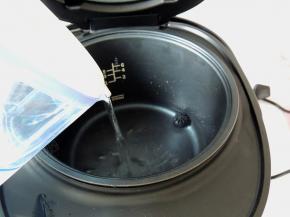 往巧釜电饭煲的三角釜里面倒入适量清水。