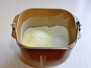 首先将面粉，奶粉，细砂糖放入面包机桶中用筷子搅拌一下。