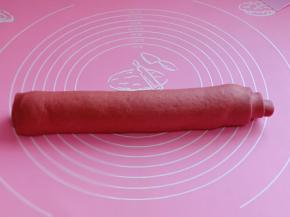 醒好的面团用擀面杖擀成大面皮，两个颜色擀成同样大，之后叠加再一起，卷起来，什么颜色在外面可以根据个人喜好来决定，我是一半红色再外面，一半白色再外面。