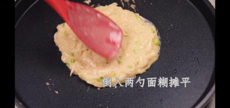 5.锅底刷油，放入两勺面糊，摊平盖盖子煎至一面金黄