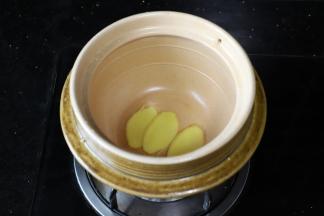 在土锅底放入三片姜片。