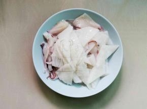 鱿鱼撕去黑色皮，洗净改花刀再切片