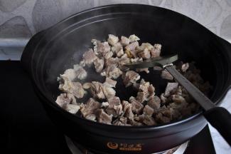 锅中不放油，将捞出的牛肉放在锅中干煸炒，这样做，可以炒出牛肉本身含有的水份，让肉更香，同进还可以逼出牛肉上面的油腻。待牛肉表面微微泛有焦焦的色，就可以了。加入姜片、八角再炒一下。