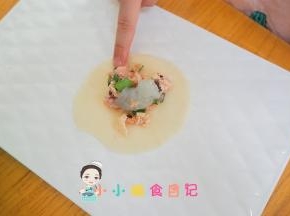 准备饺子皮放入肉馅加一颗虾仁，周围沾水对半粘合即可
