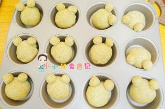 在连接处涂一点水沾上，耳朵最好放在模具的上面，搁住，不然发酵会把耳朵挤压变形，仔细看我是面团不是放正中间，有放边边上一点，这样可以把耳朵搁在模具的边缘一点的位置