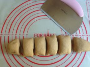 把发酵好的面团取出放在揉面垫上，使劲揉面，若面团太粘手的话，可以在揉面垫上撒上一些面粉，把案板上的面粉再揉入面团。我一般会揉几分钟时间，把面团里的气泡都揉出来，这样切面就没有气孔，蒸出来的馒头会特别光滑。好多人蒸出来的馒头不光滑，是由于这一步没有做好，没有充分揉面团。揉好的面团搓成长条，切成若干等份