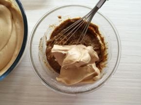 把1/3打发好的蛋白霜舀入到蛋黄糊里，用手动打蛋器从底部向上翻拌均匀