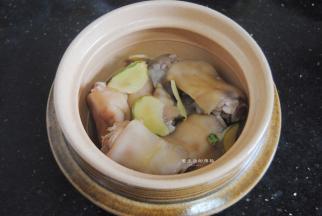 将焯水过的猪蹄放入砂锅里，放入姜片和大蒜。