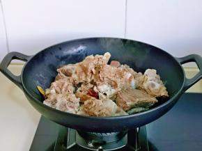 起油锅，加入香料，小火炒出香味，再加入牛大骨翻炒。