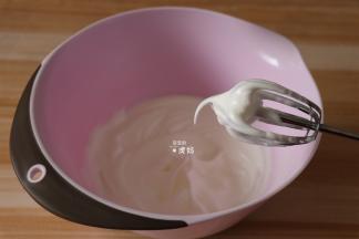 蛋白中滴3滴白醋，将白砂糖分三次加入到蛋白里，打发到湿性发泡，即提起打蛋器可以出现弯钩，如图；