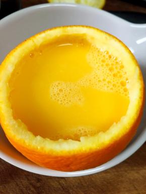 把鸡蛋打散，与橙汁混合均匀。混合好的液体倒入之前挖好的橙子中。