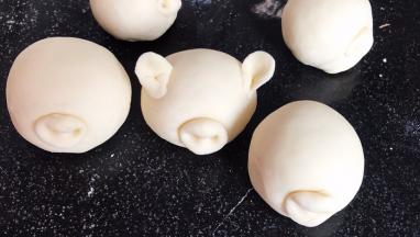 在猪嘴巴上插上鼻子，再把剩下的面团做出耳朵