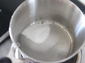 首先来制作焦糖，糖和水混合，热水最后加，放入小锅中，开小火，晃动锅子，让水和糖混合。