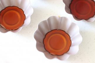 趁热把焦糖液体，倒入到学厨玛芬模具中，没过底部一点就可以了，大约这个量，分了8杯。放置等待焦糖稍微凝固。