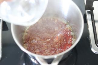 倒入热水，此时糖浆会沸腾，需要注意。然后快速的搅拌均匀。糖的颜色也变成透明的焦糖色。