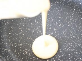 倒入适量的面糊到不粘平底锅中，开小火烙饼。饼出现小气泡后，翻面。