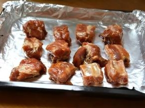 4 腌好的排骨码放在铺了锡纸的烤盘上，腌排骨的料汁不要倒掉；