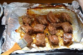 7 将烤盘端出，表面的锡纸去掉，用刷子蘸剩余的酱汁刷在排骨表面；