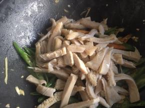 炒至青椒断生后，倒入牛肚丝继续翻炒；